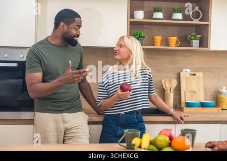Giovane coppia felice che si gode del tempo libero a casa, in piedi in cucina, a fare colazione, alla routine mattutina. Persone adorabili amano le attività del fine settimana Foto Stock