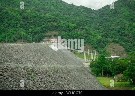 Costruzione di creste in cemento armato della diga con terrapieno per il riempimento della roccia che mostra la moderna ingegneria delle infrastrutture idroelettriche per una maggiore sostenibilità Foto Stock