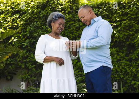 Al matrimonio, la coppia senior si scambiava anelli in giardino, celebrando l'amore e l'impegno all'aperto Foto Stock