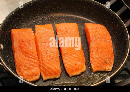 Primo piano di filetti di salmone fresco che si cuocono in padella Foto Stock