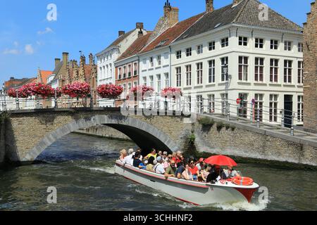 Turisti che visitano la città su una chiatta sotto il ponte Sint-Annarei a Bruge, Belgio Foto Stock