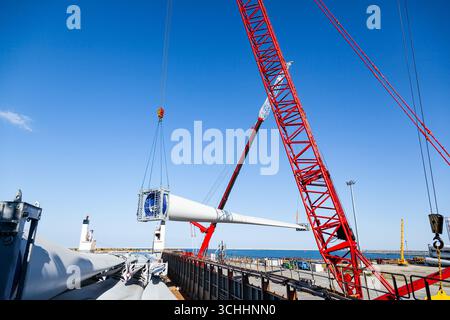 Constanta, Romania - 08.03.2022 - carico nel porto marittimo della Romania con le pale dei mulini a vento Vestas, due gru per nave da carico. Foto Stock