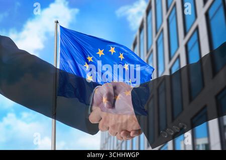 Uomini d'affari che stringono la mano, esposizione multipla agli edifici e alla bandiera dell'Unione europea. Successo in partnership, accordo, accordo Foto Stock