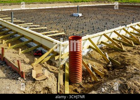 Costruzione di fondazioni in cemento armato con rete in acciaio e installazione di tubi di drenaggio Foto Stock