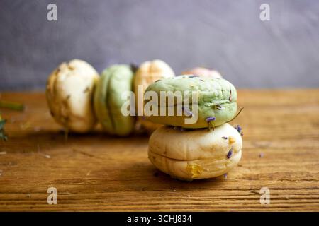 Saponette naturali fatte a mano con erbe e fiori su un tavolo di legno. Prodotti per la cura della pelle ecologici, cosmetici biologici e concetto di benessere con lavanda e. Foto Stock