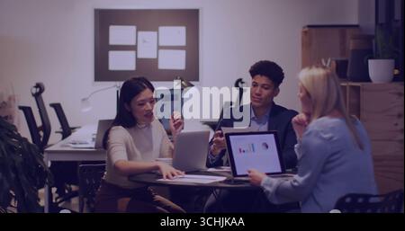 Discutendo i dati, tre colleghi analizzano i grafici sui notebook alla tavola rotonda in ufficio con i report Foto Stock