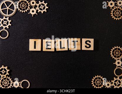 IELTS, testo su pannelli di legno sullo sfondo di un ufficio robotico. Foto Stock