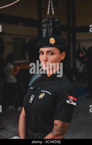 Ritratto di una donna della Gendarmeria in uniforme, in piedi all'interno di una base militare. Foto Stock