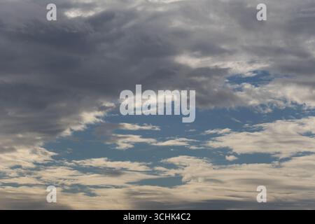 Quest'immagine cattura un cielo sereno pieno di nuvole mostruose in sfumature di grigio e blu, creando un'atmosfera tranquilla e ampia, perfetta per la natura. Foto Stock