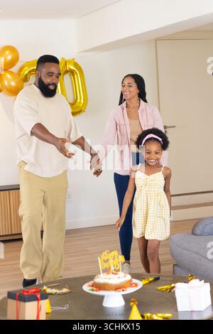 Festeggiamo il compleanno, la famiglia felice si diverte con dolci e regali a casa Foto Stock