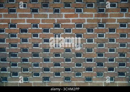 Parete in mattoni stilizzata con inserti geometrici e caratteristiche di design uniche Foto Stock