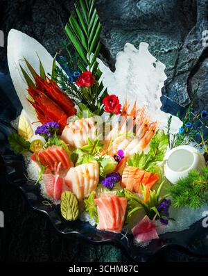 Piatto di sashimi assortito con salmone e gamberi su ghiaccio Foto Stock