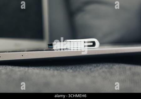 L'unità USB Silver è posizionata su un computer portatile. Il notebook è spento Foto Stock