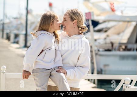 Madre con figlia vicino al molo con gli yacht Foto Stock