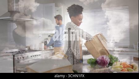 Disimballaggio di una cuoca casalinga che prende oggetti da un sacchetto di carta sull'isola di cucina in marmo, spazio copia Foto Stock