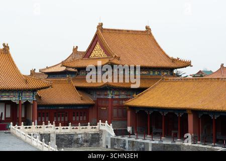 Tradizionale complesso di palazzi cinesi con iconici tetti dorati-gialli, grondaie dipinte ornate, colonne rosse e terrazze in marmo bianco. Foto Stock