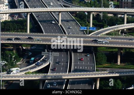 Vista dall'alto di un complesso interscambio autostradale multilivello con il traffico in una città moderna. Foto Stock
