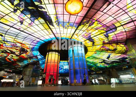 Vista dall'angolo basso dei turisti sotto la spettacolare installazione artistica "Cupola della luce" nella stazione di Formosa Boulevard, Kaohsiung. Foto Stock
