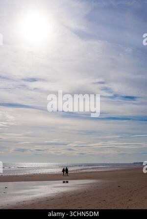 Coppia che cammina lungo la spiaggia di Drudge Bay con la bassa marea Foto Stock