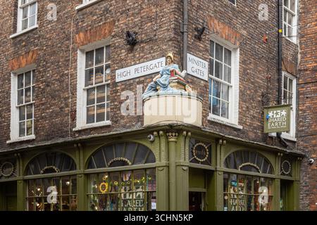 Statua di Minerva sopra un negozio all'angolo tra High Petergate e Minster Gates a York, Inghilterra, una popolare attrazione turistica. Foto Stock