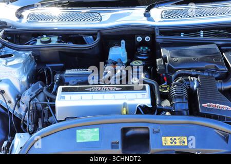 Questa foto è una foto ravvicinata del vano motore di un'auto in una giornata di sole. Il motore color argento con coperchio a marchio "Works" è la caratteristica centrale. Sono visibili vari altri componenti del motore, tra cui serbatoi, tubi di aspirazione dell'aria e cablaggio. Sono visibili anche la carrozzeria argentata della vettura e il cofano parzialmente aperto. Illustrativo, editoriale: Lo Stokes Bay Car Rally a Gosport, Hampshire, Inghilterra. 25 agosto 2025. Foto Stock