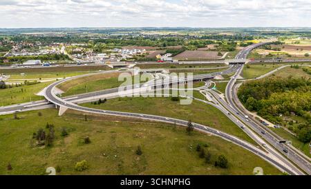 Veduta aerea di un grande interscambio autostradale in Polonia con cavalcavia e campi circostanti che mostra infrastrutture stradali complesse e pianificazione del traffico Foto Stock