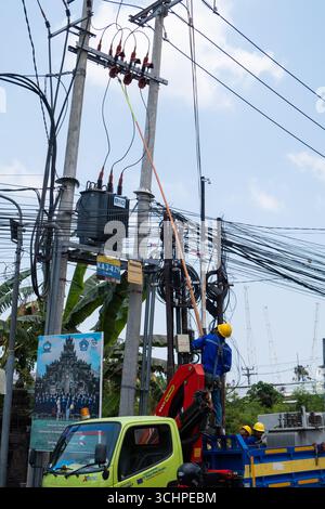 CANGGU, BALI - 24 ottobre: I lavoratori elettrici installano un nuovo trasformatore di sottostazione a Canggu, Bali, Indonesia il 24 ottobre. Foto Stock