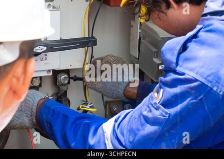 CANGGU, BALI - 24 ottobre: I lavoratori elettrici installano un nuovo trasformatore di sottostazione a Canggu, Bali, Indonesia il 24 ottobre. Foto Stock