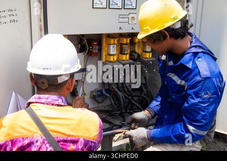 CANGGU, BALI - 24 ottobre: I lavoratori elettrici installano un nuovo trasformatore di sottostazione a Canggu, Bali, Indonesia il 24 ottobre. Foto Stock