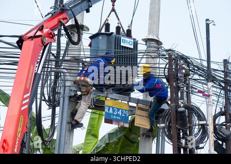 CANGGU, BALI - 24 ottobre: I lavoratori elettrici installano un nuovo trasformatore di sottostazione a Canggu, Bali, Indonesia il 24 ottobre. Foto Stock