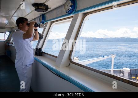 AMBON, INDONESIA - maggio 29: Secondo ufficiale guarda l'orizzonte. Gli ufficiali DELLA KM Pangrango guidarono la loro nave fuori dal porto di Ambon, Indonesia Foto Stock