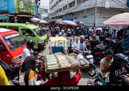 AMBON, INDONESIA - marzo 28: Una folla di acquirenti e veicoli si ostacola per la posizione al mercato principale di Ambon il 28 marzo. Foto Stock