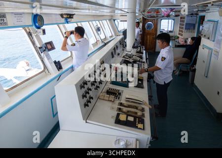 AMBON, INDONESIA - maggio 29: Quartermaster al timone mentre il secondo ufficiale osserva l'orizzonte con un binocolo. Gli ufficiali della KM Pangrango hanno guidato il loro Foto Stock