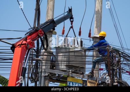 CANGGU, BALI - 24 ottobre: I lavoratori elettrici installano un nuovo trasformatore di sottostazione a Canggu, Bali, Indonesia il 24 ottobre. Foto Stock