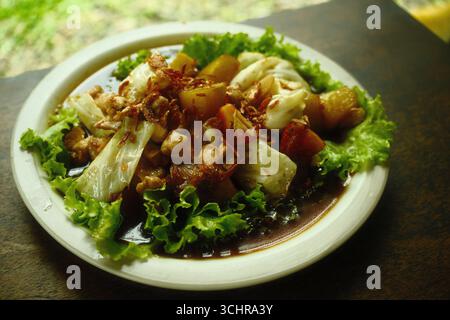 Un piatto di pollo e patate fritte in padella con salsa di soia dolce e lattuga Foto Stock