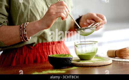 Donna che prepara tè verde Matcha Close-up View Sifting Tea Foto Stock