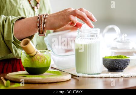 Donna che prepara il tè verde Matcha con un primo piano di ghiaccio Foto Stock