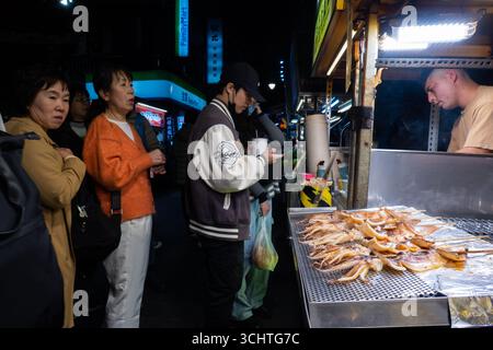 TAIPEI, TAIWAN - 18 dicembre: La gente del posto acquista cibo dai venditori ambulanti. Folle di persone hanno affollato il mercato notturno di Shilin il 18 dicembre a Taipei, Taiwan. Foto Stock
