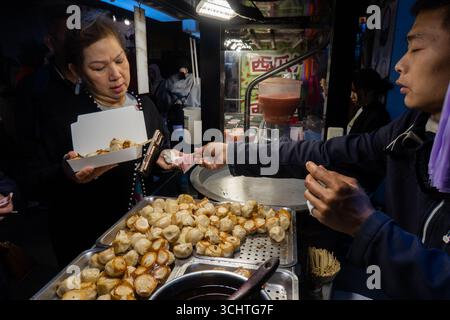 TAIPEI, TAIWAN - 18 dicembre: La gente del posto acquista cibo dai venditori ambulanti. Folle di persone hanno affollato il mercato notturno di Shilin il 18 dicembre a Taipei, Taiwan. Foto Stock