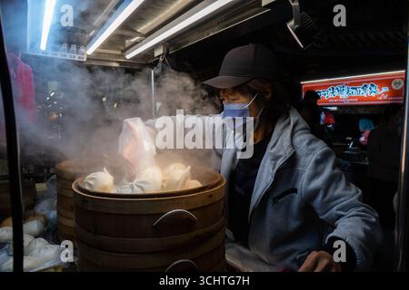 TAIPEI, TAIWAN - 18 dicembre: Il venditore di ravioli di riso Bao prepara le sue merci. Folle di persone hanno affollato il mercato notturno di Shilin il 18 dicembre a Taipei, Taiwan. Foto Stock