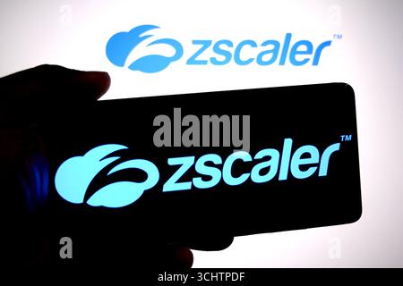 In questa immagine, il logo Zscaler viene visualizzato su uno smartphone e sullo sfondo. Foto Stock