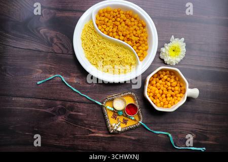 Un primo piano di tradizionali spuntini indiani. croccanti salati sev e dolci boondi dorati serviti insieme. Sapori perfetti in un autentico nome indiano. Foto Stock