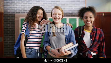 Studenti delle scuole superiori, amici e sorrisi con ritratti per il supporto didattico, l'apprendimento o la conoscenza. Adolescenti, ragazze e contenti di libri di testo Foto Stock
