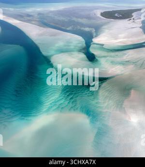 La vista aerea delle sabbie mutevoli crea schemi ipnotici in cui le acque turchesi si incontrano con le coste bianche incontaminate, Moreton Island, Queensland, Australia. Foto Stock
