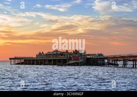 Molo di Birnbeck al tramonto, nel canale di Bristol a Weston-super-Mare, Regno Unito, all'inizio del restauro con impalcature su di esso Foto Stock