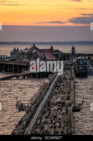 Molo di Birnbeck al tramonto, nel canale di Bristol a Weston-super-Mare, Regno Unito, all'inizio del restauro con impalcature su di esso Foto Stock