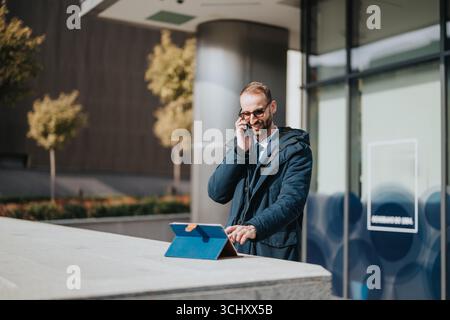 Uomo d'affari che utilizza la tecnologia all'aperto durante una conversazione telefonica Foto Stock