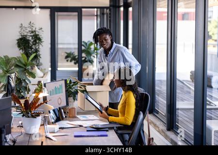 In ufficio, i colleghi esaminano i documenti e discutono insieme i dettagli del progetto Foto Stock