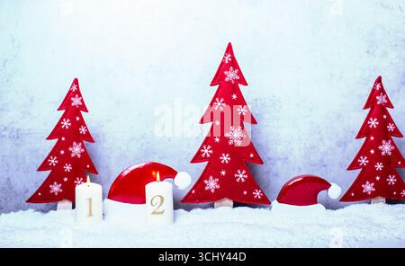Decorazioni natalizie con abeti rossi e cappelli di Babbo Natale nella neve per il 2° Avvento, composizione Foto Stock
