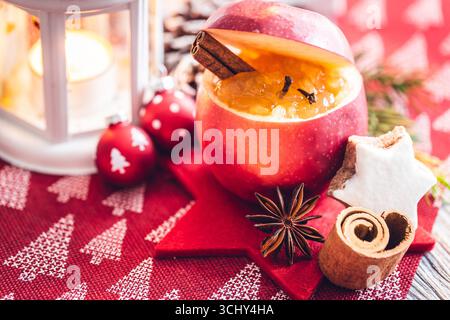 Decorazioni natalizie con mele, noci, coni, rami di abete, bastoncini di cannella, anice stellato e lume di candela, composizione Foto Stock